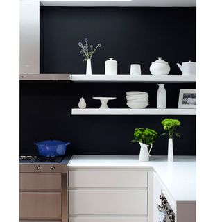 kitchen room with white shelves on black wall