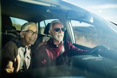 Happy senior couple going on a trip by car.