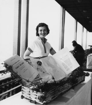 Black and white photo of a woman behind a book