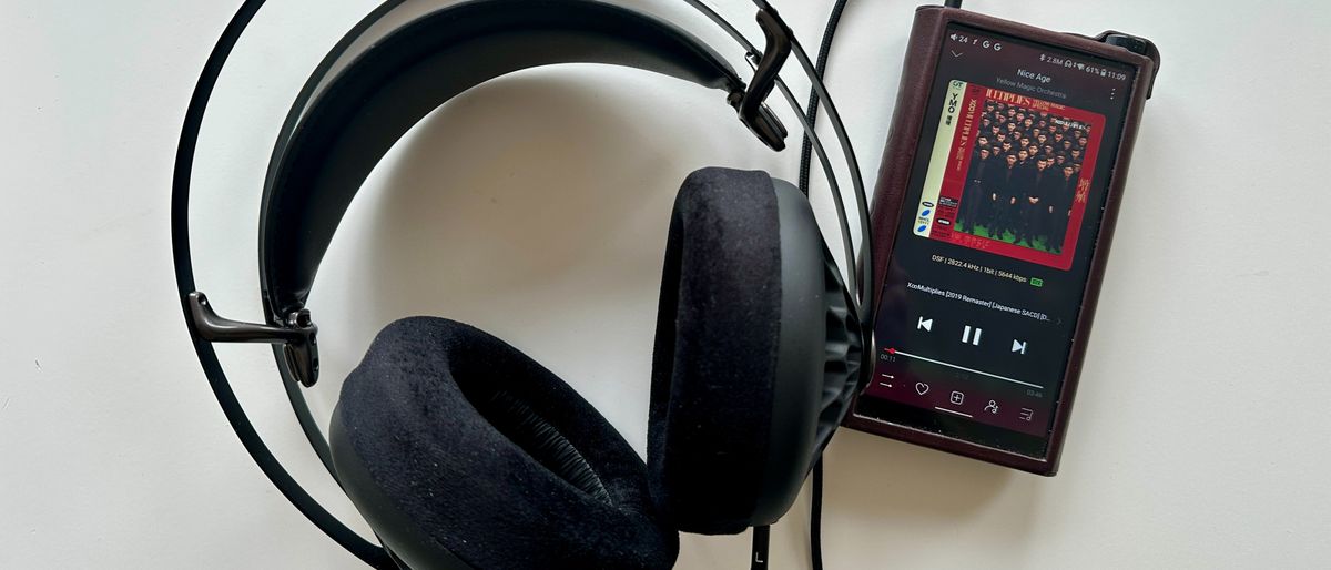 Meze Audio 105 AER headphones next to a hi-res audio player, on a gray table