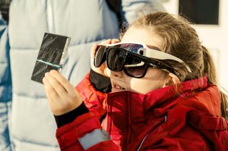 Total Solar Eclipse showing people wearing glasses and looking at the eclipse