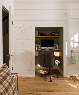 bedroom workspace in cupboard with paneled walls and wooden floors