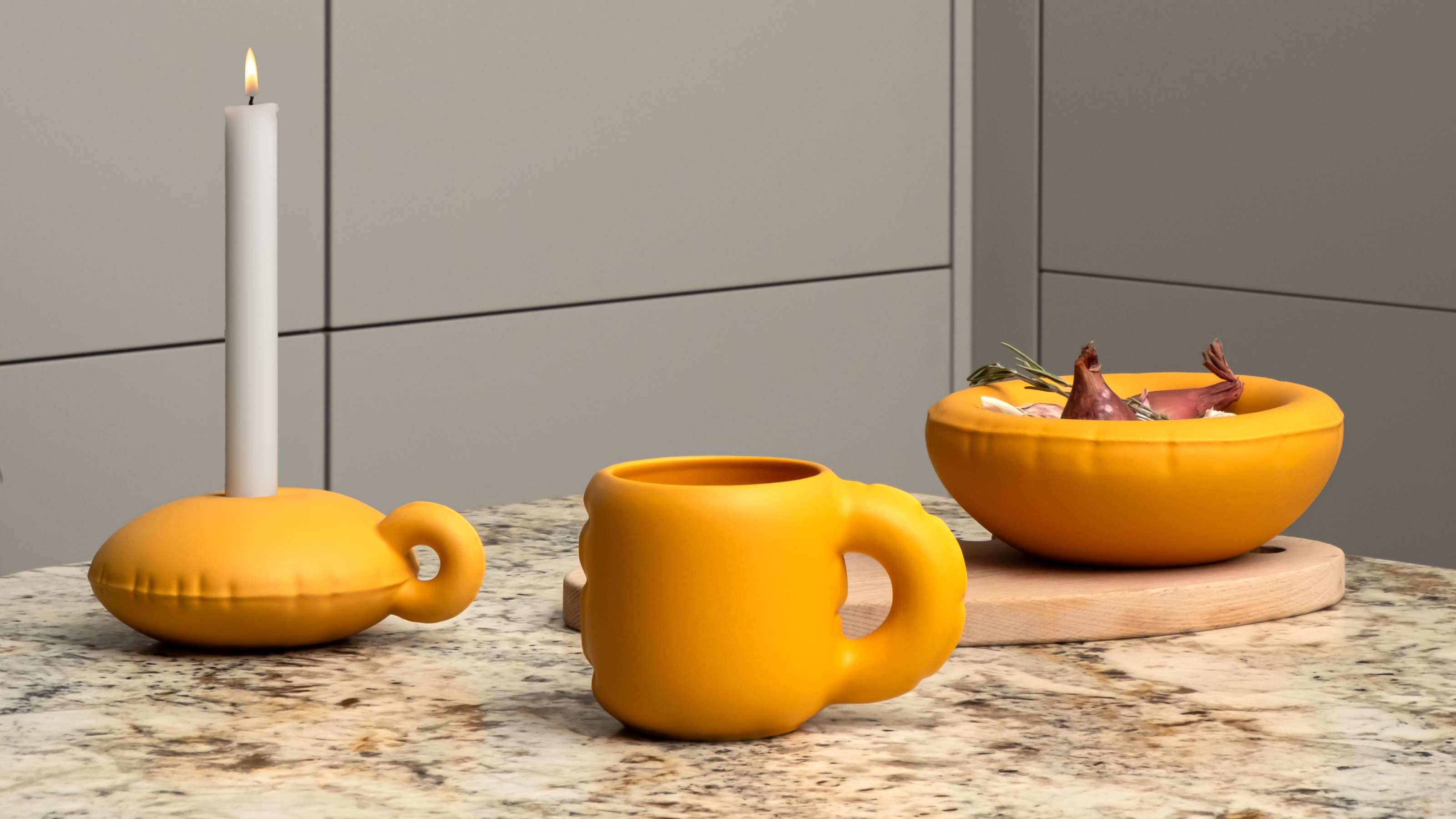 an orange candle holder, mug, and bowl with an inflated style
