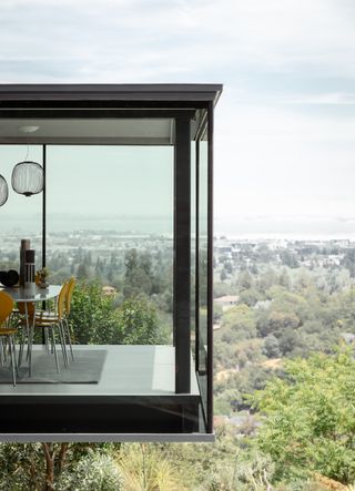 jewel box by red dot studio, a house jutting out of a leafy hill and looking out to views from large glazed side