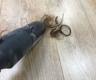 Brigii handheld vacuum vacuuming hair from hardwood floor