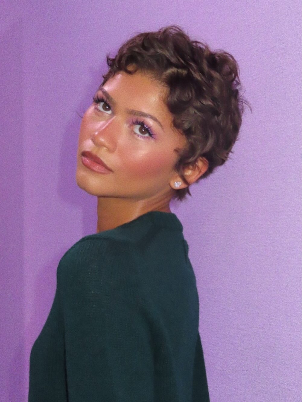 Zendaya with a pixie haircut and soft highlights in her brunette hair