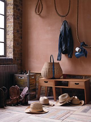 Light brown entryway with cowboys hat and cowboy boots scattered across the floor.