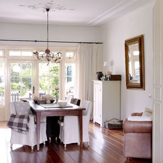 dining room with white wall and wooden dining table and cupboard