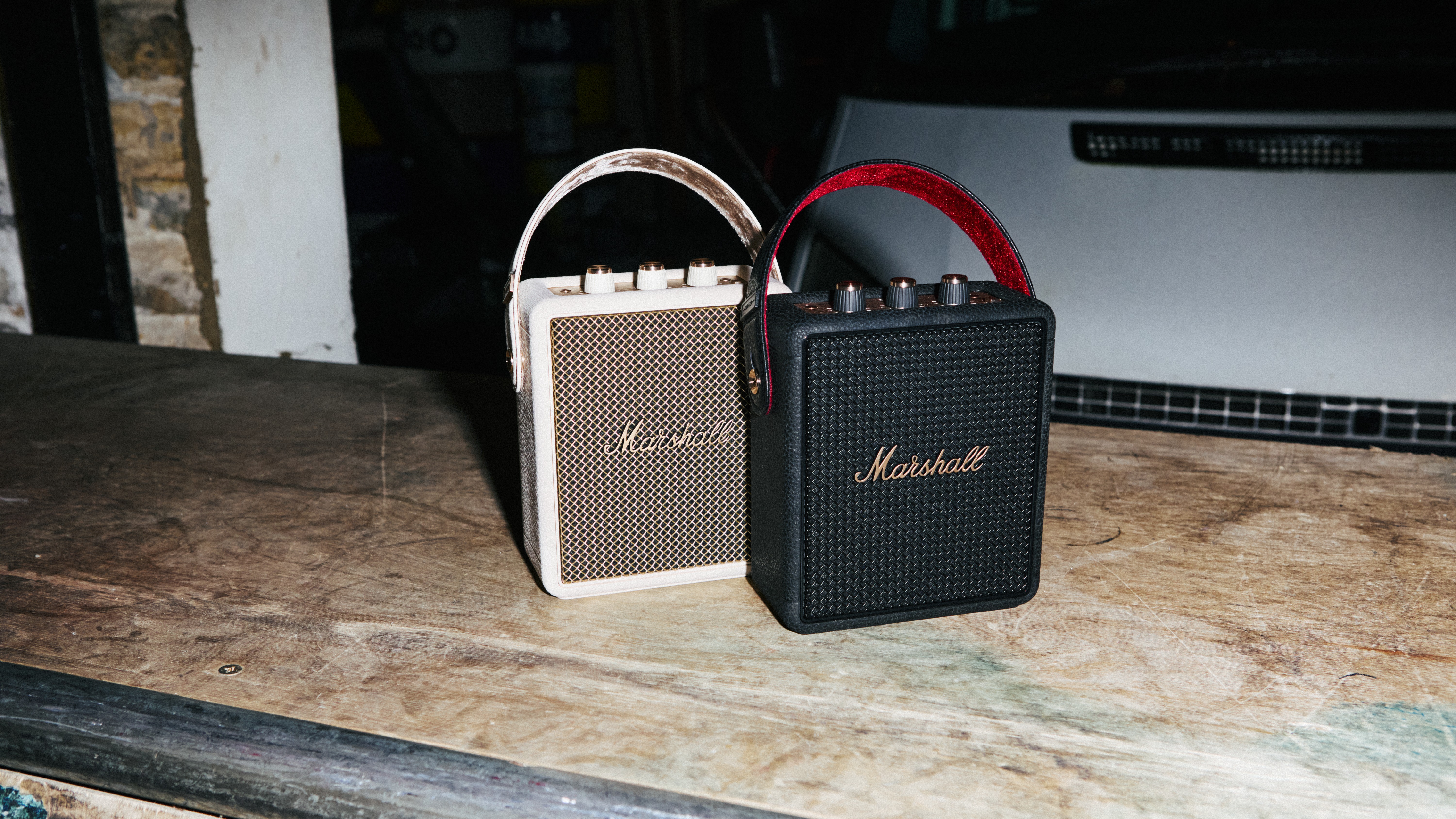 Two Marshall Stockwell III speakers, one in cream and one in black and gold