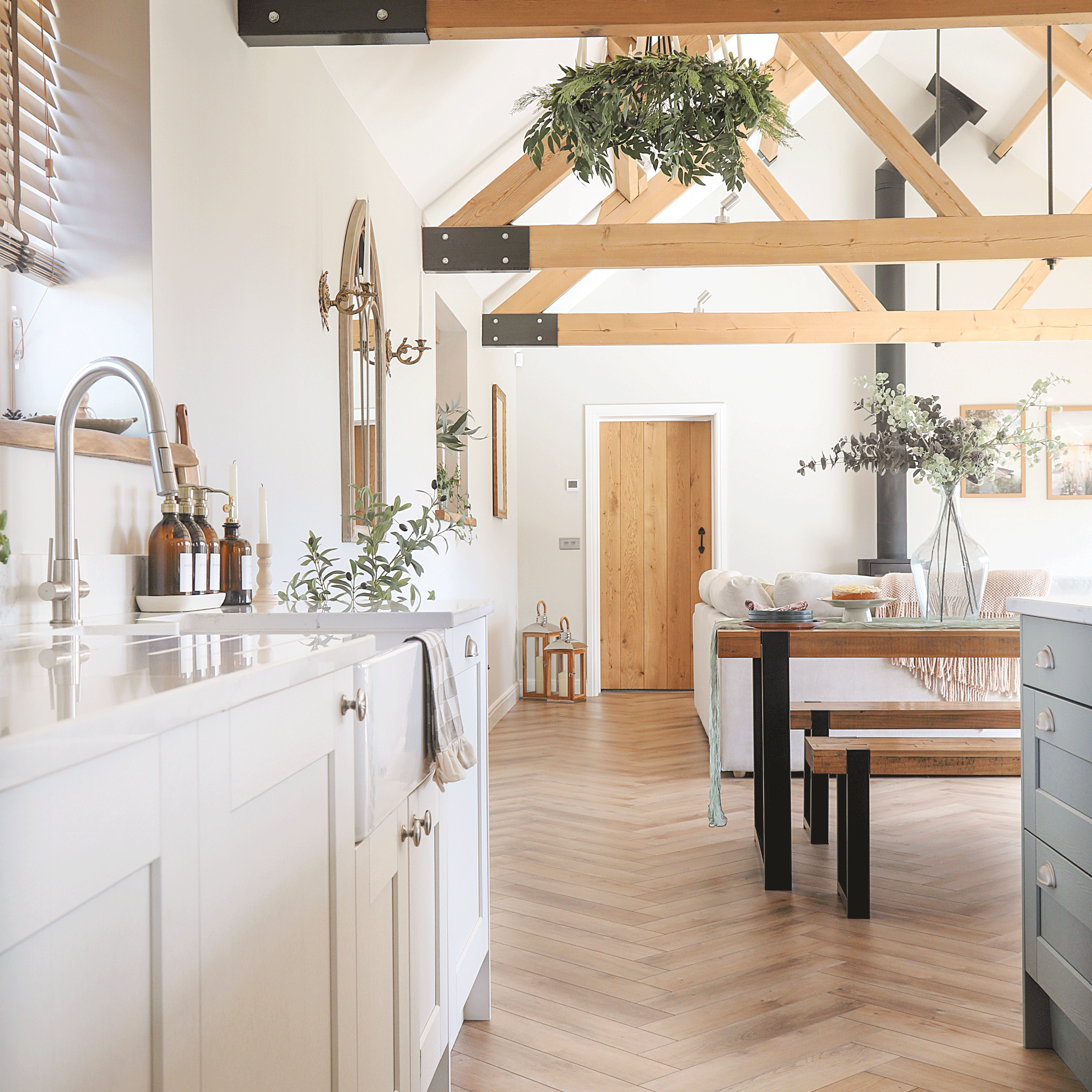 an open plan kitchen dining living space with vaulted ceilings and herringbone flooring