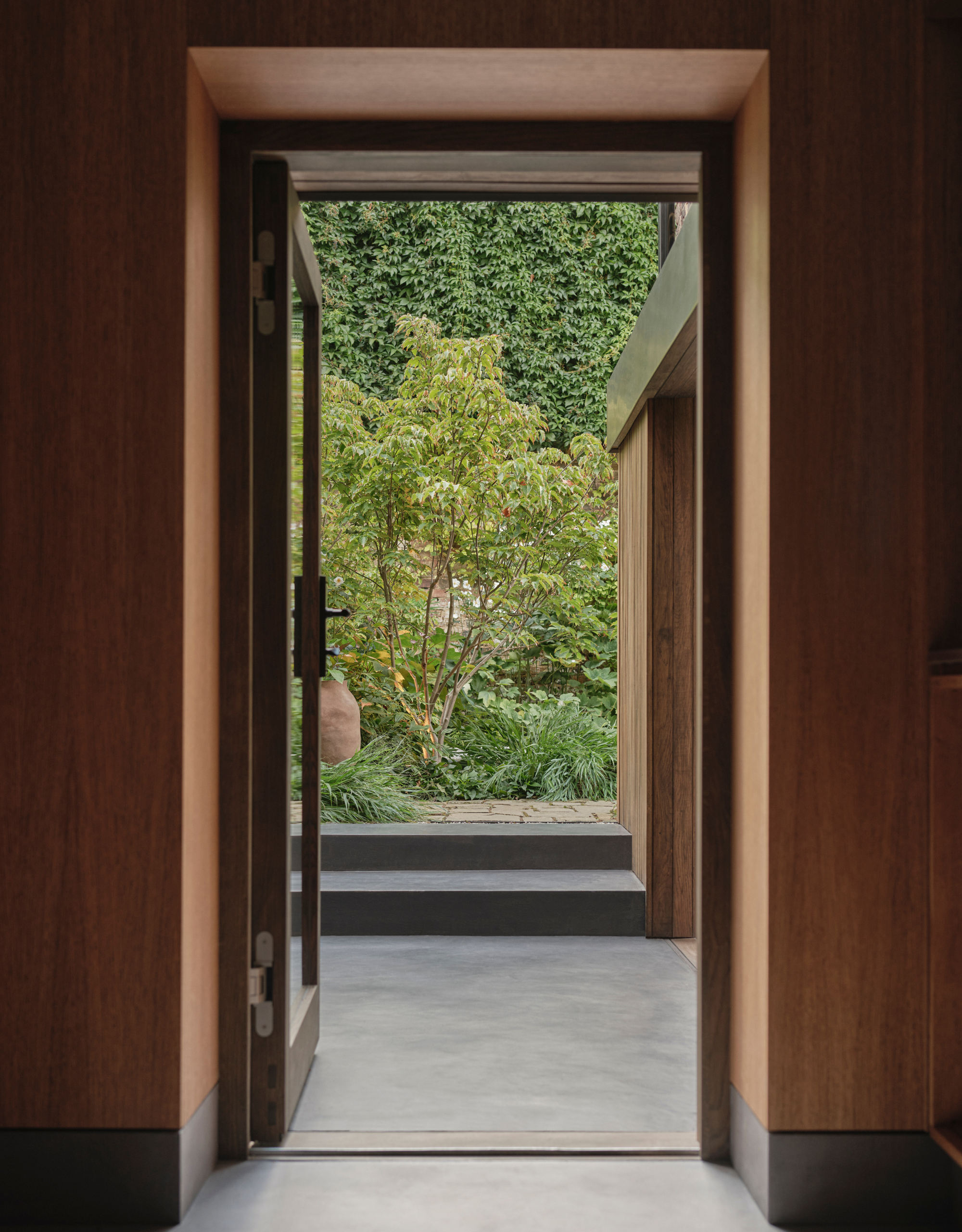 A wood-drenched room leading out into a Japanese courtyard