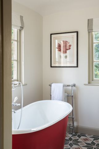 bathroom with red bath and patterned tiled floor
