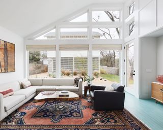 A bright and airy lounge area with a large rug and glass patio doors