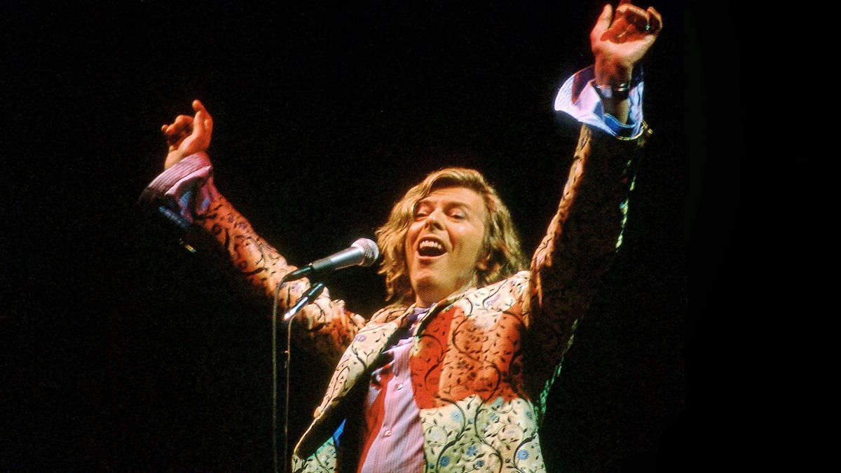 David Bowie performs live on the Pyramid stage wearing a coat designed by Alexander McQueen, at the Glastonbury festival at Worthy Farm on June 25, 2000 in Pilton, United Kingdom.