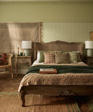 bedroom with green walls, rattan bed, tapestry throw on wall