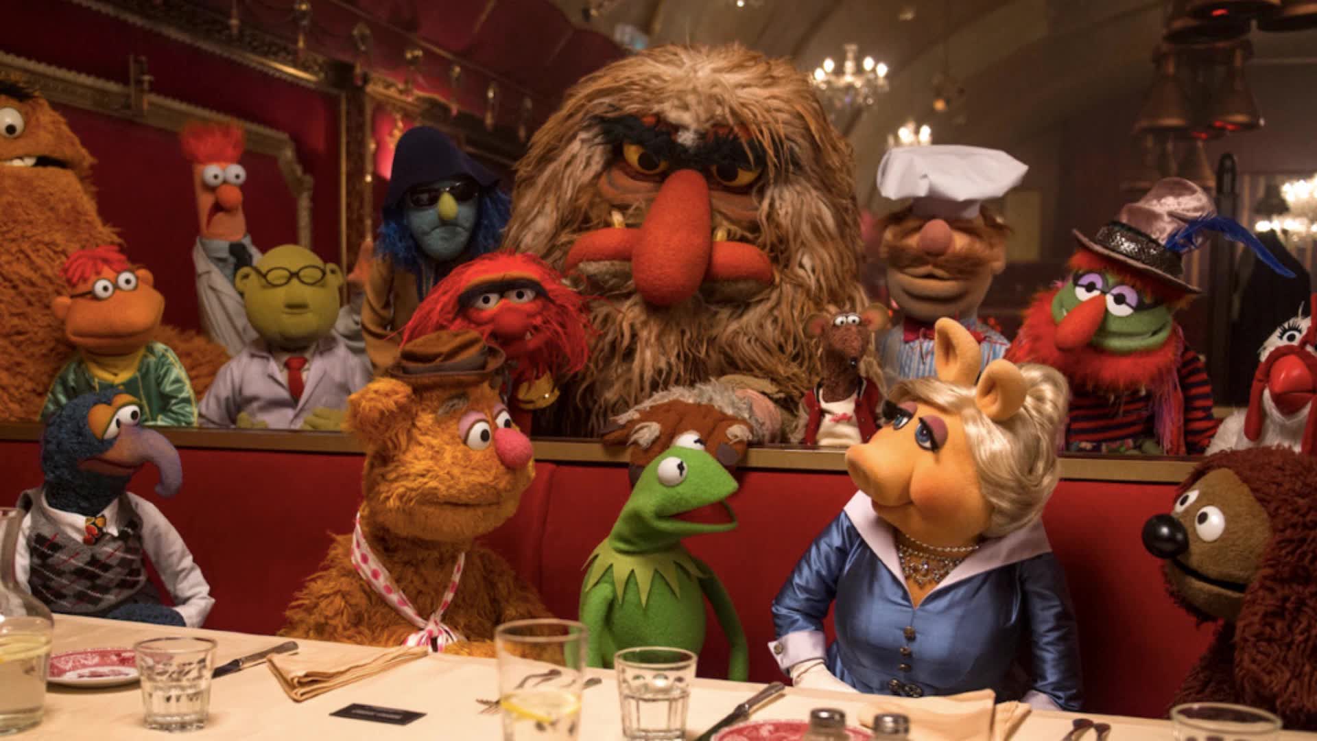 The Muppets sat around a table in a restaurant 