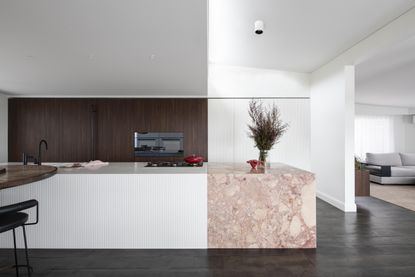 A pink marble kitchen countertop in a monochrome kitchen