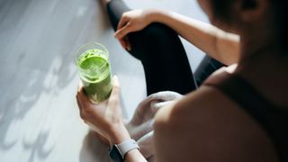 Image shows person holding smoothie