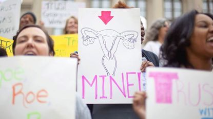 Woman holding self-made sign of fallopian tubes