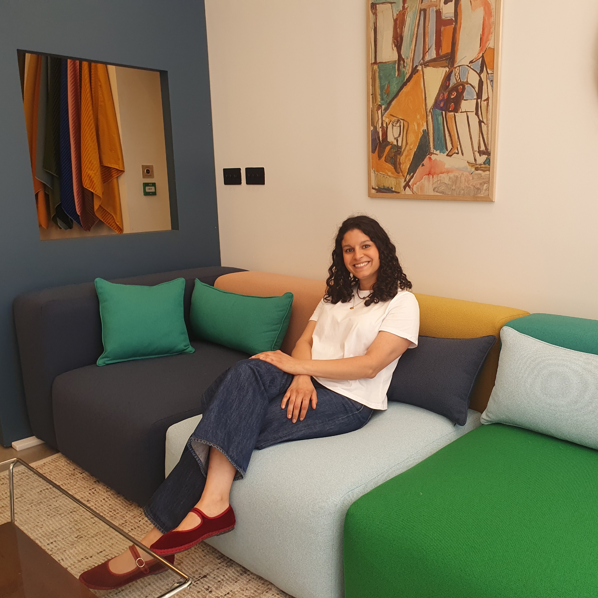 Sara at the Sazy London showroom sitting on the multi-coloured modular Cob sofa