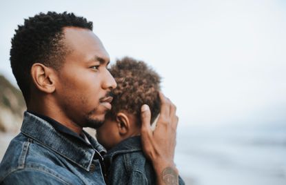 Father with male postnatal depression holding his baby