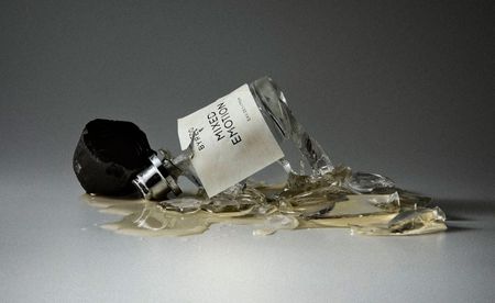 Bottle of byredo mixed emotions perfume smashed on the floor against grey background