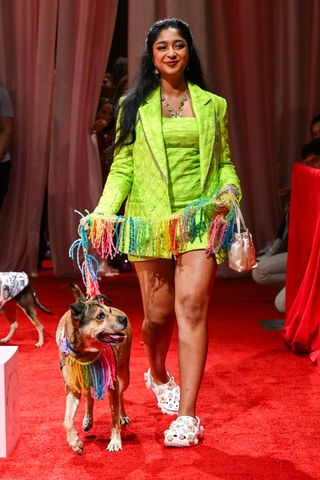 a model walks the susan alexandra rachel antonoff runway with a rescue dog on a rainbow leash