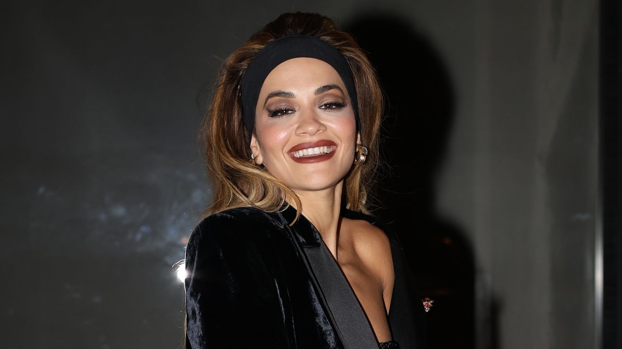 Rita Ora wears teased hair with a thick black headband in Paris.