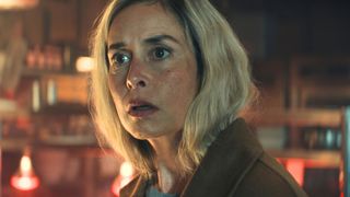 A woman looks shocked at something offscreen