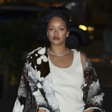 Rihanna stuns once again in NYC with an oversized cowhide print coat over her underwear, a brown quilted handbag with gold chain detailing, and matching lace-up heels. Gold accessories add a touch of glam, with her hair styled up to highlight the look.