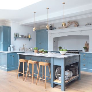 blue shaker-style kitchen with blonde wooden floor