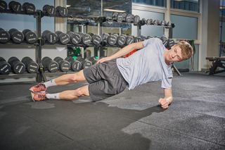 Male cyclist holding a side plank position as part of a bone health boosting routine