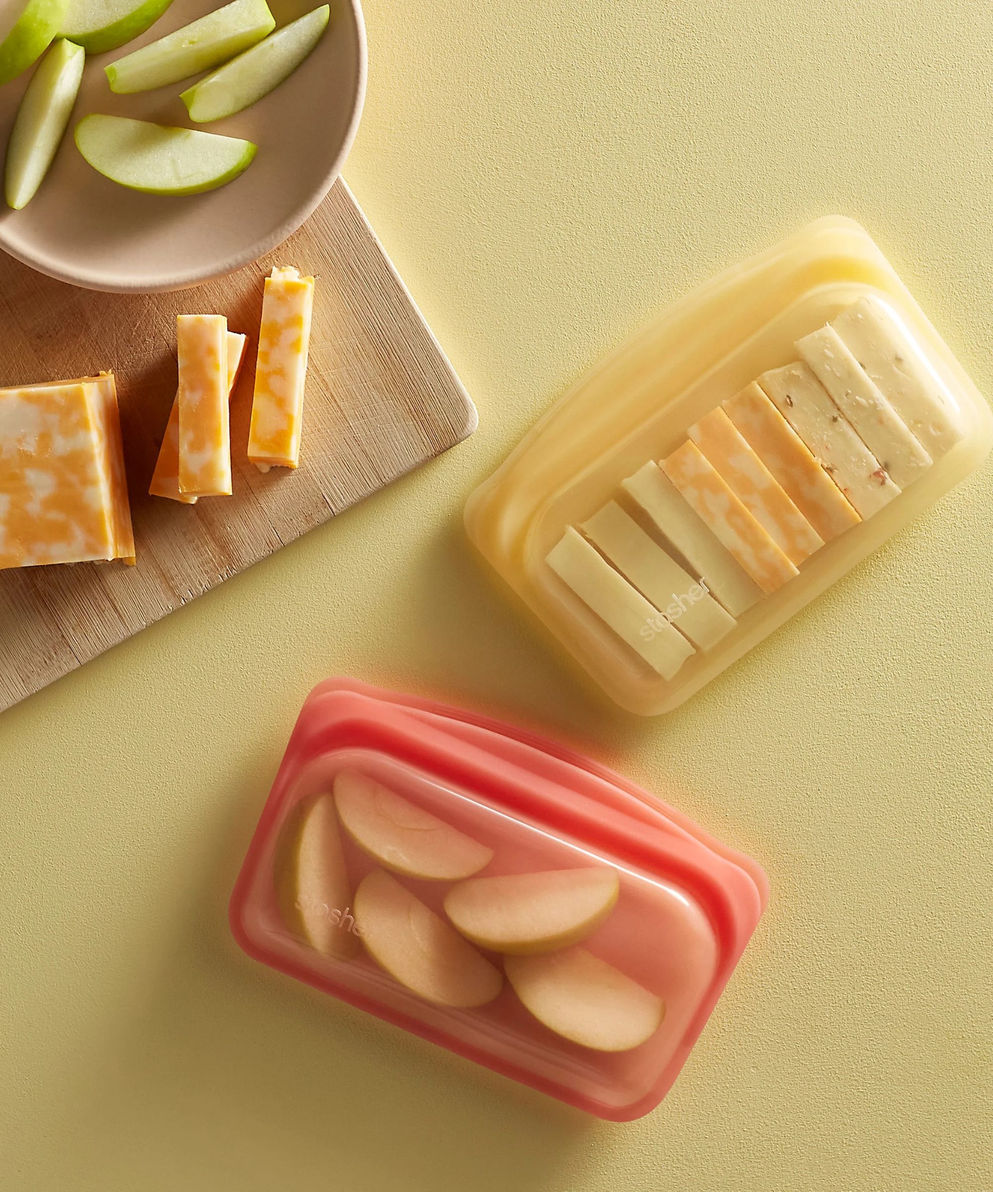 Red and yellow silicone food storage bags on a yellow table.