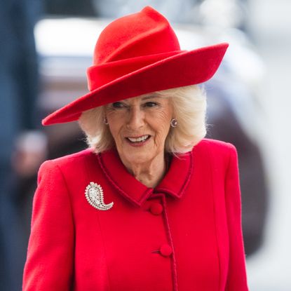 Queen Camilla wearing a red hat and coat