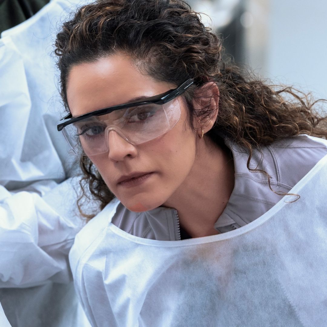 Sepideh Moafi as dr. al-hashimi wearing goggles and a white cover up while in surgery in a still from the pitt season 2