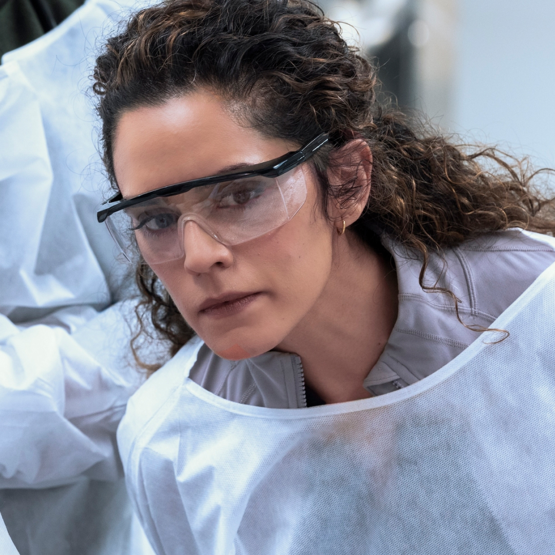 Sepideh Moafi as dr. al-hashimi wearing goggles and a white cover up while in surgery in a still from the pitt season 2