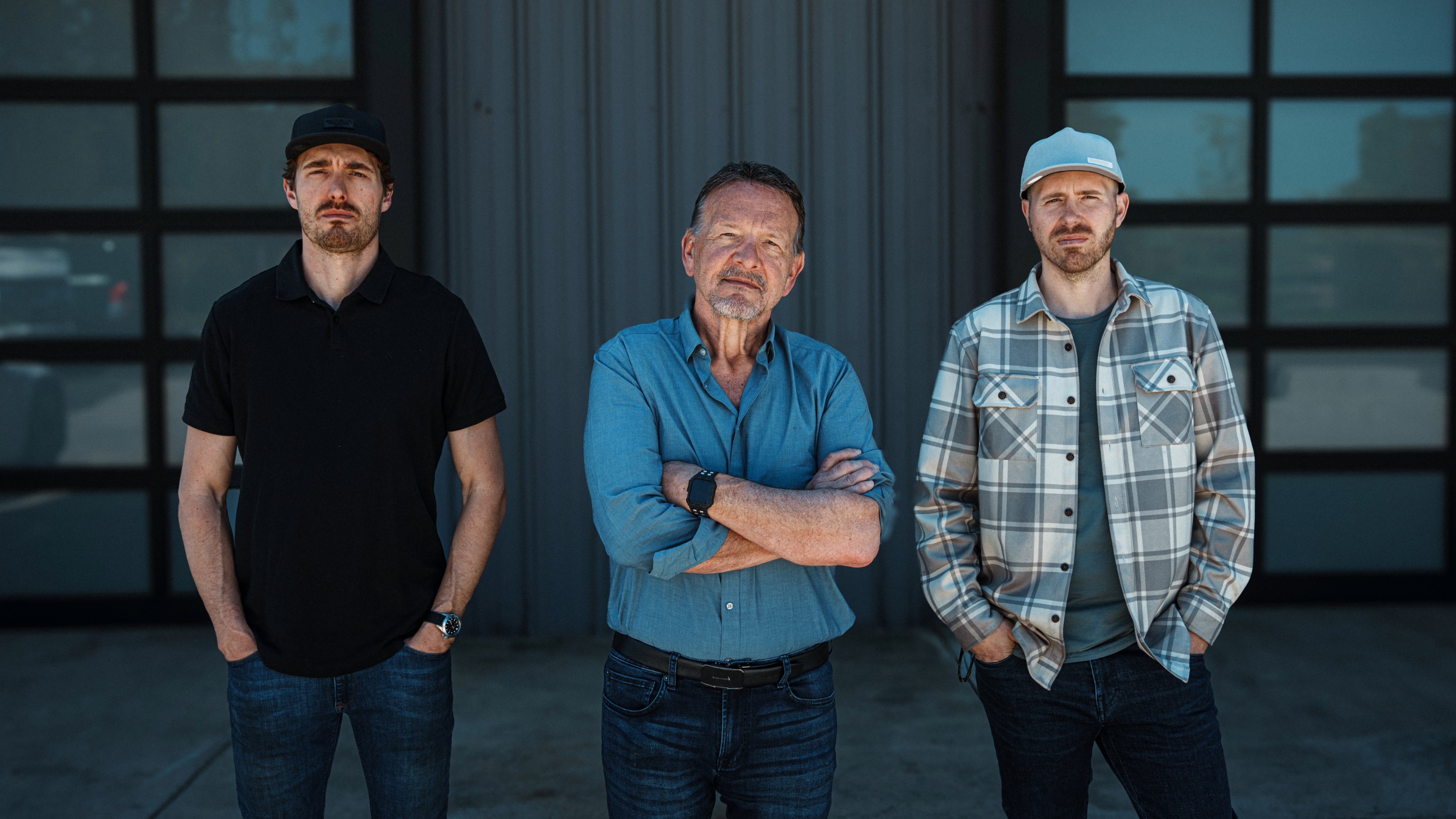 Mature man with his two adult sons outside their warehouse