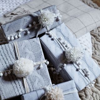 presents wrapped in knitted photographic gift wrap with knitted pom pom decorations
