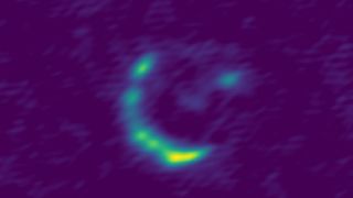 A radio telescope image of the 'invisible' galaxy from the early universe being gravitationally lensed by another object