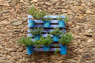 blue painted pallet made into planter with flowerpots
