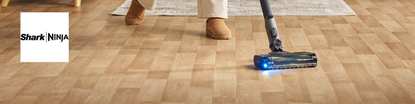 sharkninja logo left with a wide image of someone hoovering