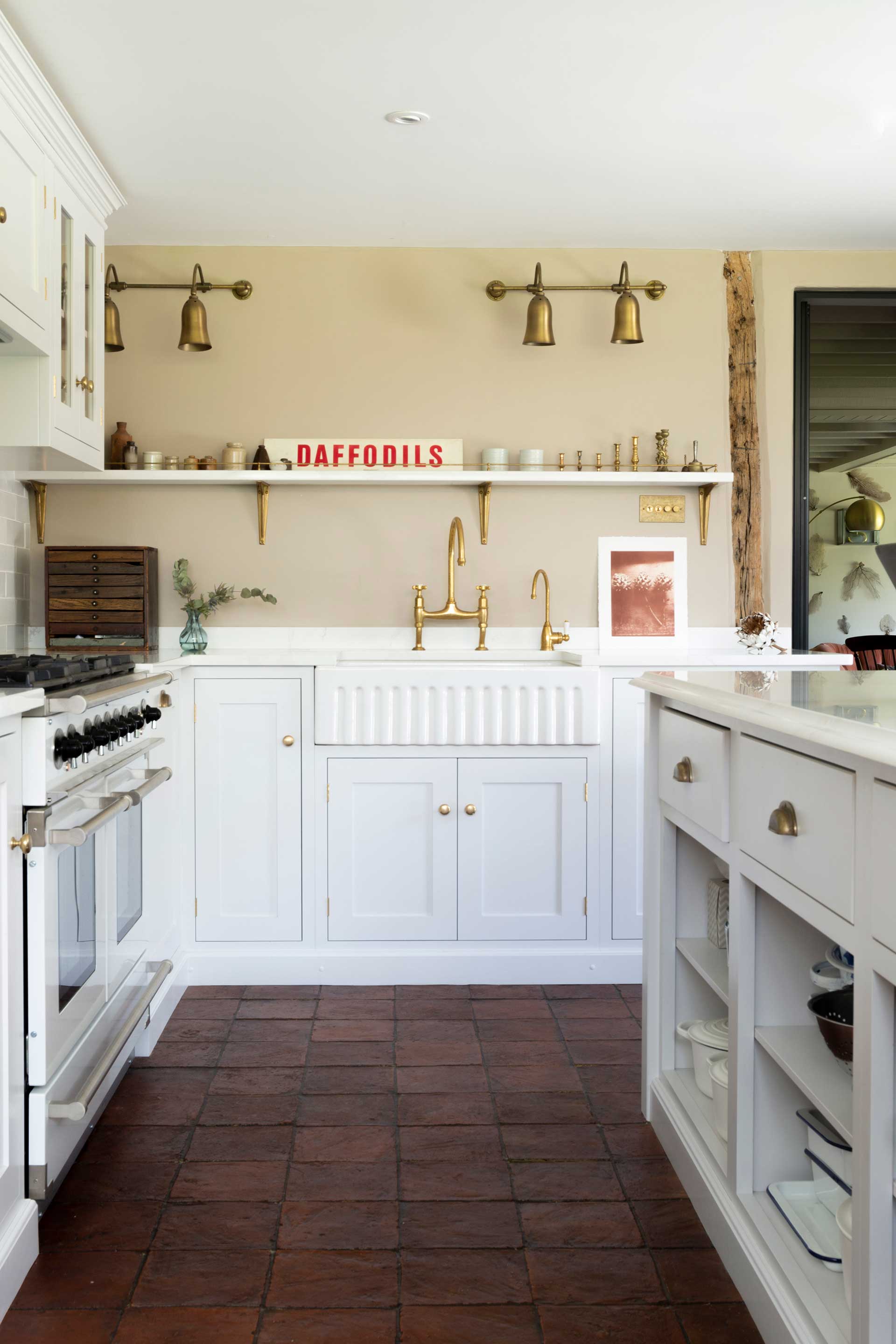 white vintage kitchen with red terracotta tiled floor adn cream walls