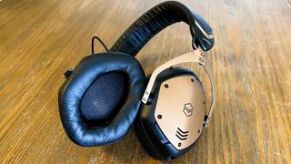 V-Moda Crossfade 3 Wireless review: headphones on a wooden table with gold plate