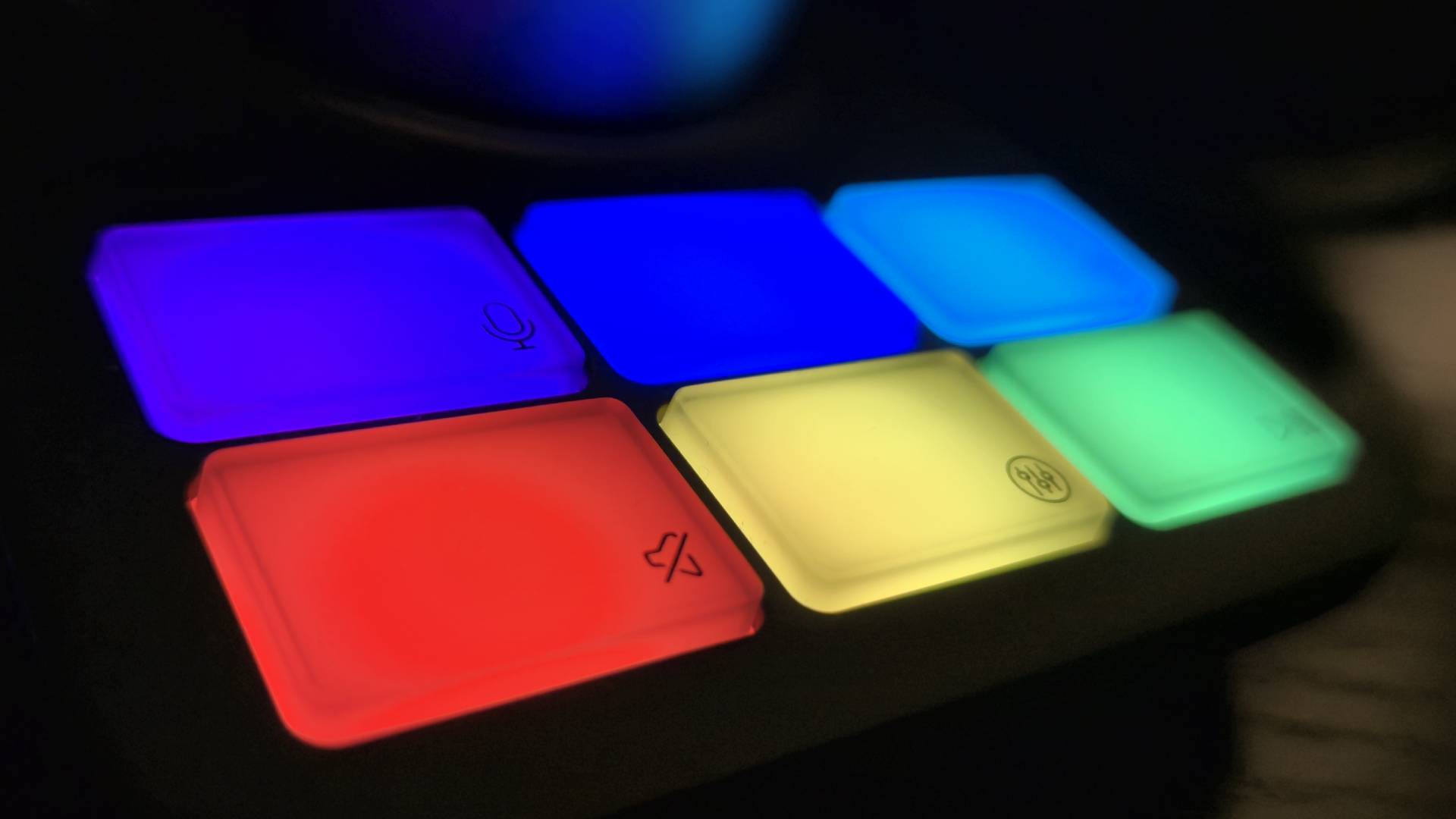 Photo showing a series of six RGB buttons on a base station headset accessory.