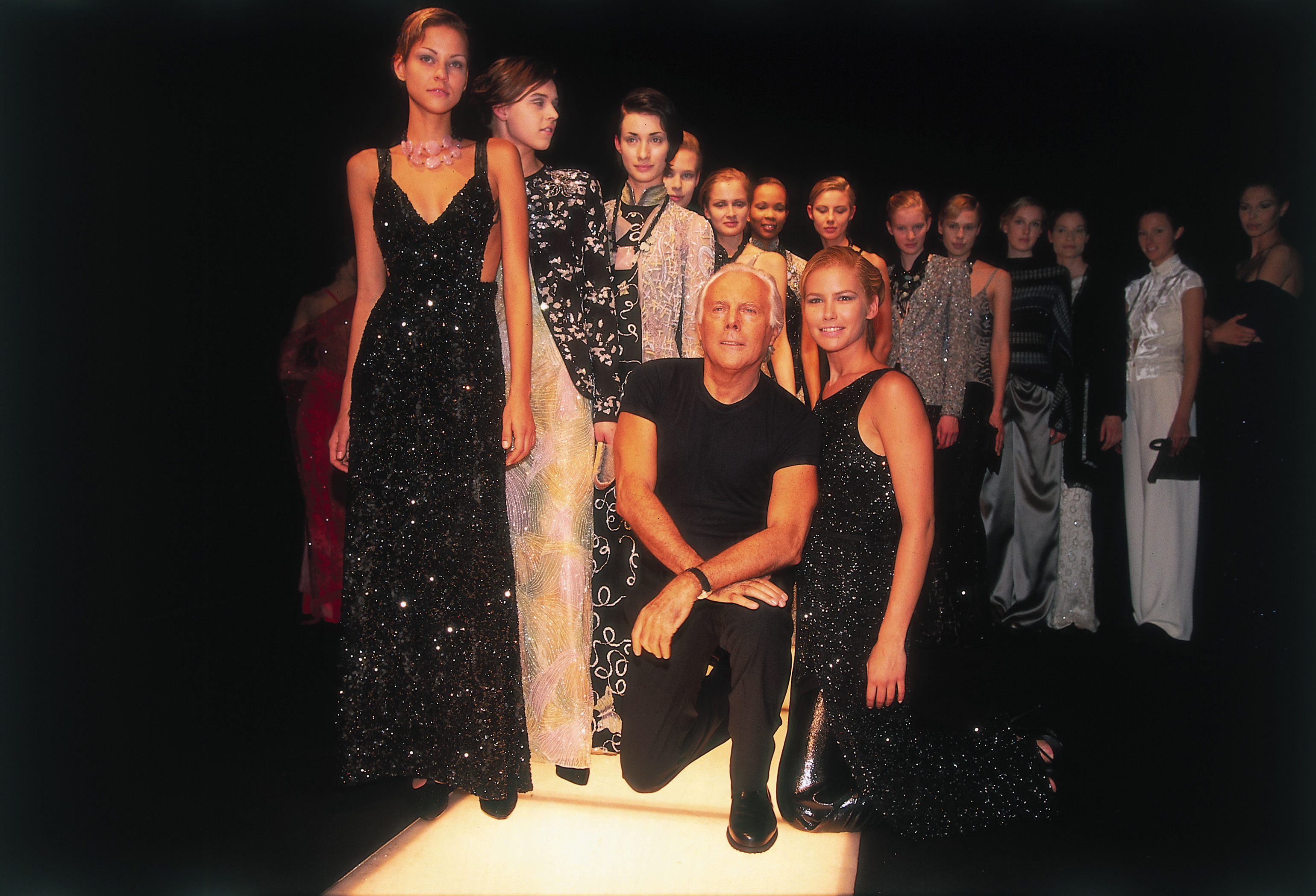 Giorgio Armani poses with models at one of his fashion shows in the 1990s