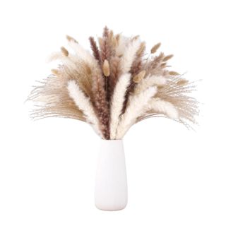 A white vase filled with white and brown pampas grass