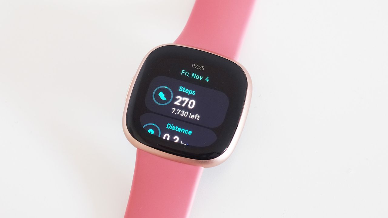 Fitbit Versa 4 with pink strap on white background