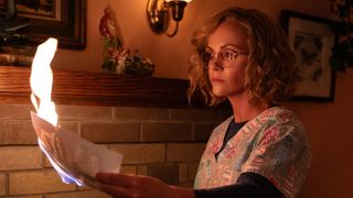 Adult Misty (Christina Ricci) burns a photograph in "Yellowjackets" season 3