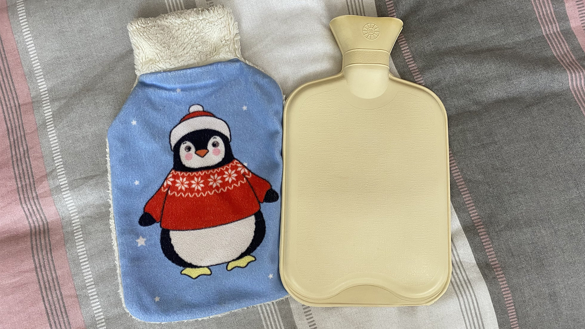 On a bed, a hot water bottle cover (left) and a hot water bottle (right)
