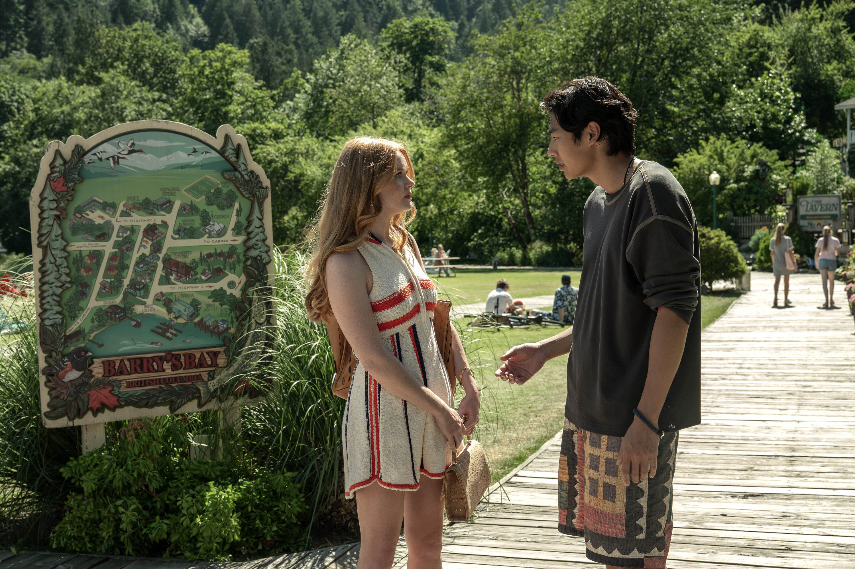 Joseph Chiu as Jordie and Abigail Cowen as Delilah talk on a dock by the barry's bay sign in every year after